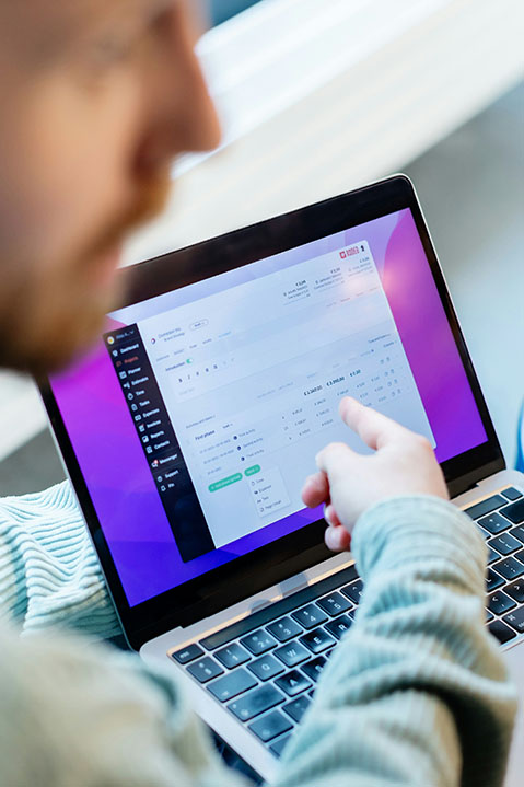 A man points to a laptop screen showing an EHR report