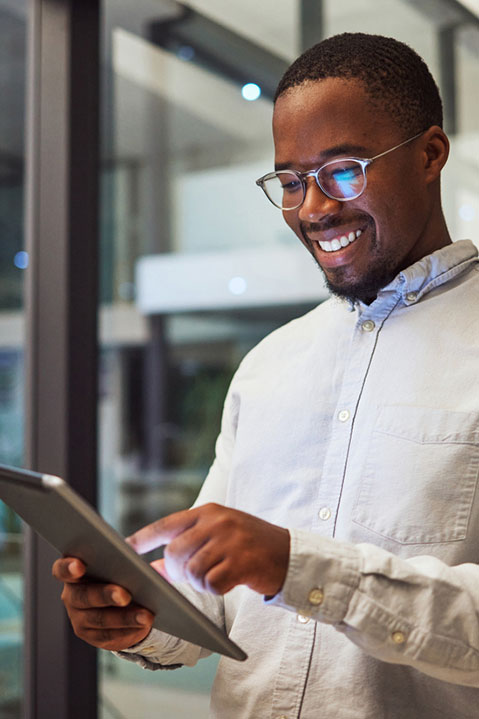 A male substance abuse clinician smiles as he uses SAMMS EHR behavioral health software on a tablet